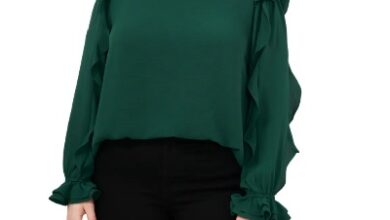A woman with long black hair wearing a green long-sleeved shirt with black pants
