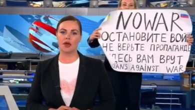 Woman causing trouble with Russian news with sign of protest against war