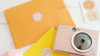 custom mail stickers added to colorful envelopes next to an instant camera