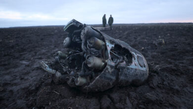 Investigators gather near fragments of a munition downed by Belarusian air defences outside the village of Harbacha in the Grodno region, Belarus, on December 29, 2022.