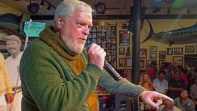 In this Saturday, July 22, 2023, photo provided by the Florida Keys News Bureau, Gerrit Marshall implores judges to choose him to win the annual Hemingway Look-Alike Contest at Sloppy Joe's Bar in Key West, Fla. (Andy Newman/Florida Keys News Bureau via AP)