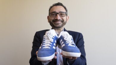 Transport Minister Omar Alghabra holds up a pair of his Adidas shoes as he poses for a photo in Ottawa on June 22, 2023. (THE CANADIAN PRESS/Adrian Wyld)
